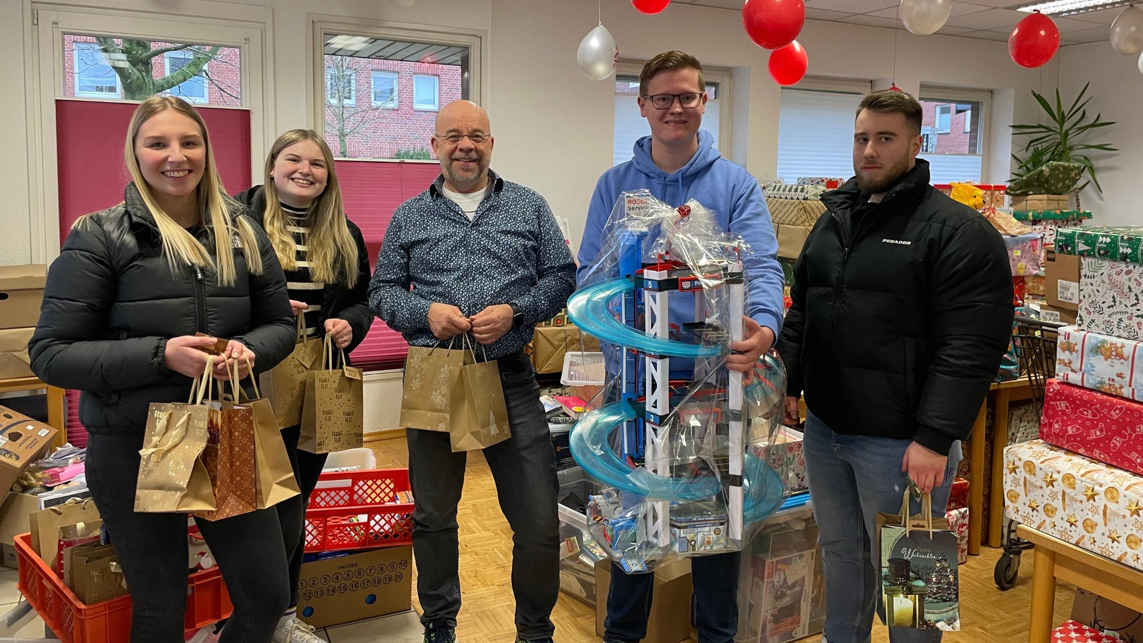 Johannes Lügering (M.) von der Ahauser Tafel  und die Auszubildenden Johanna Büscher, Alessia Bone, Nils Gieseler und Szabolcs Tamas (v.l.) bei der Übergabe der Weihnachtspäckchen.